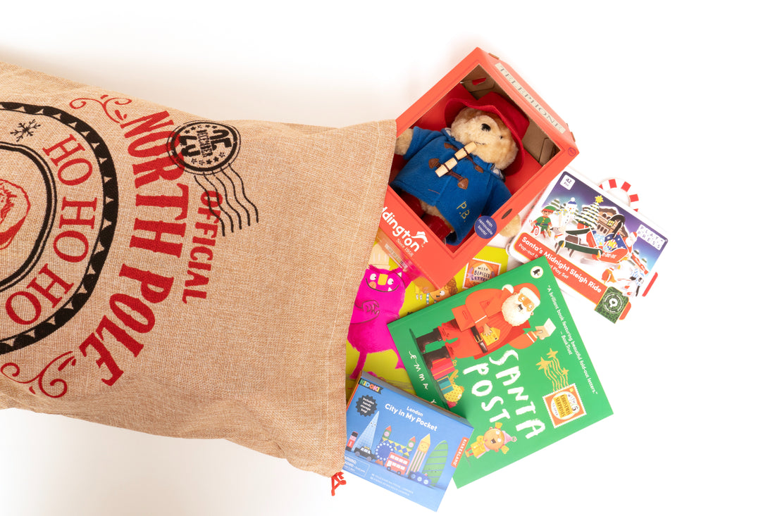 North Pole Themed hessian Sack shown on its side with presents spilling out. 