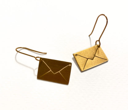 Gold envelope-shaped earrings on a white background