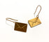 Gold envelope-shaped earrings on a white background