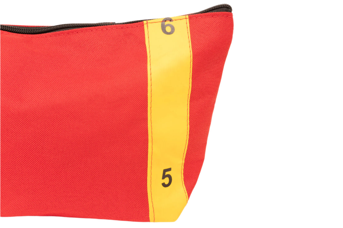 Detail of red Toiletry bag made by Flotsam Flo from recycled Royal Mail trolley sleeves. Features yellow strip