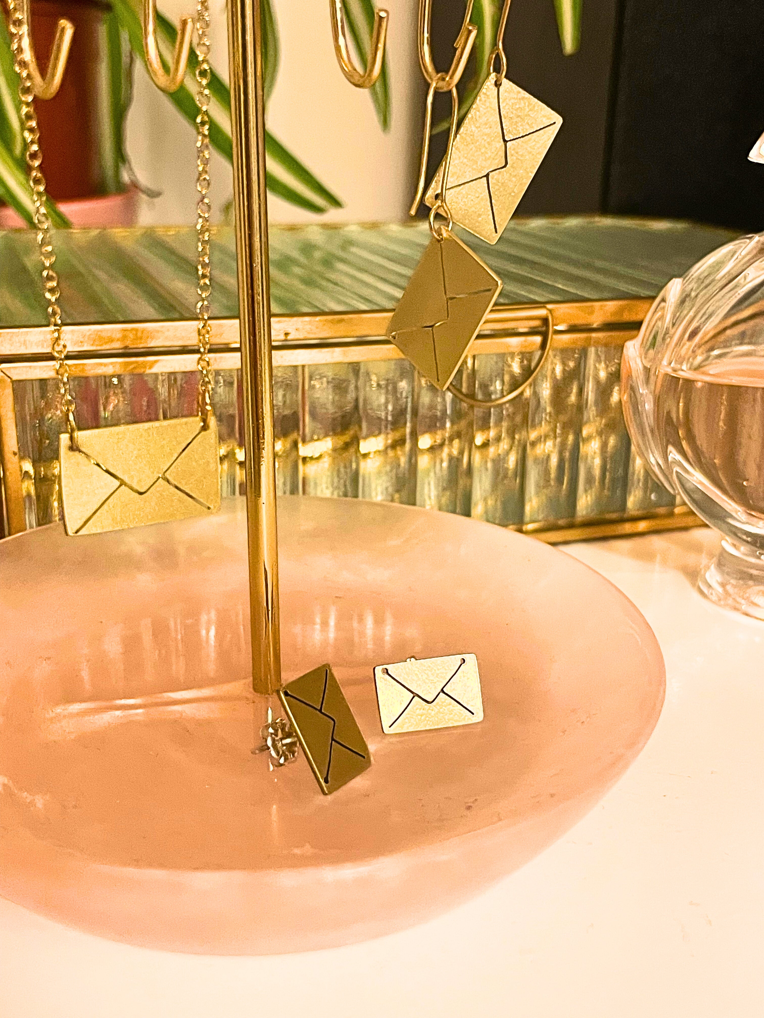 Gold earrings on a stand with a blurred background
