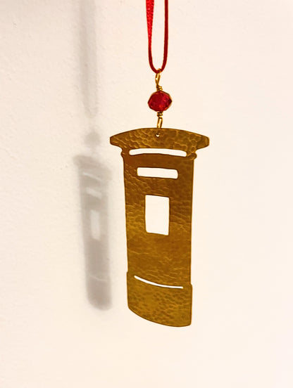 Decorative pendant with a red bead on a beige background
