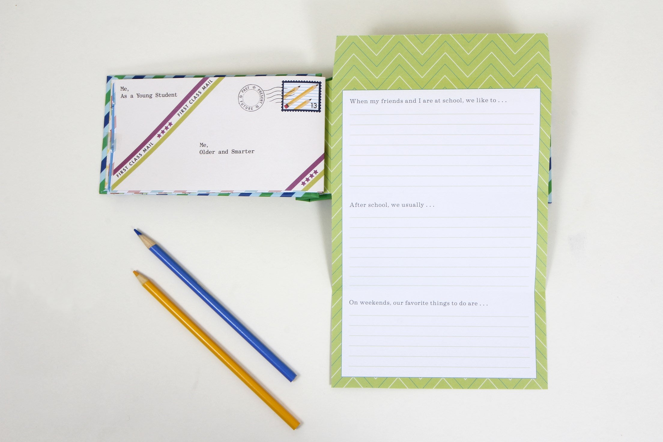 Green notepad with printed text, envelope, and two pencils on a white background