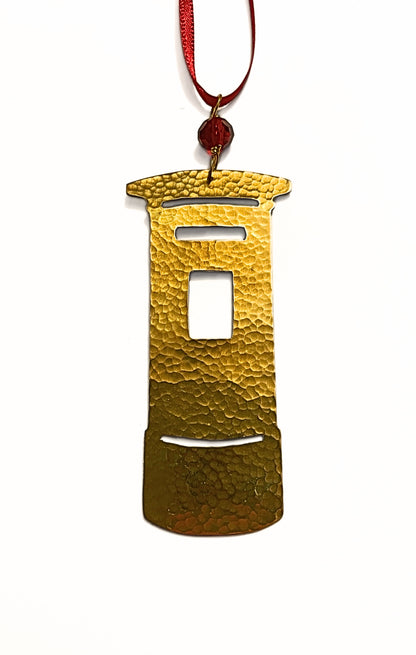 Gold ornament shaped like a traditional Post Box on a white background